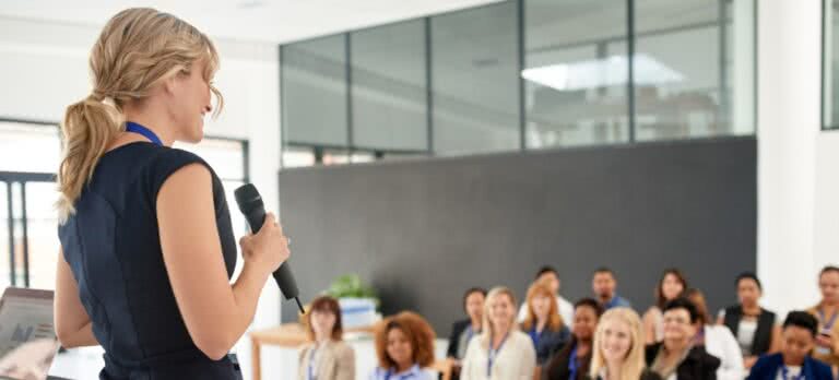 A woman speaks to a small crowd at a networking event 