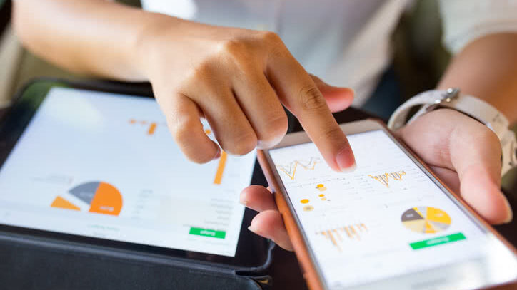 Businesswoman checks data in smartphone and tablet.