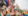 Crowd cheering and celebrating Pride while holding many rainbow flags happily.
